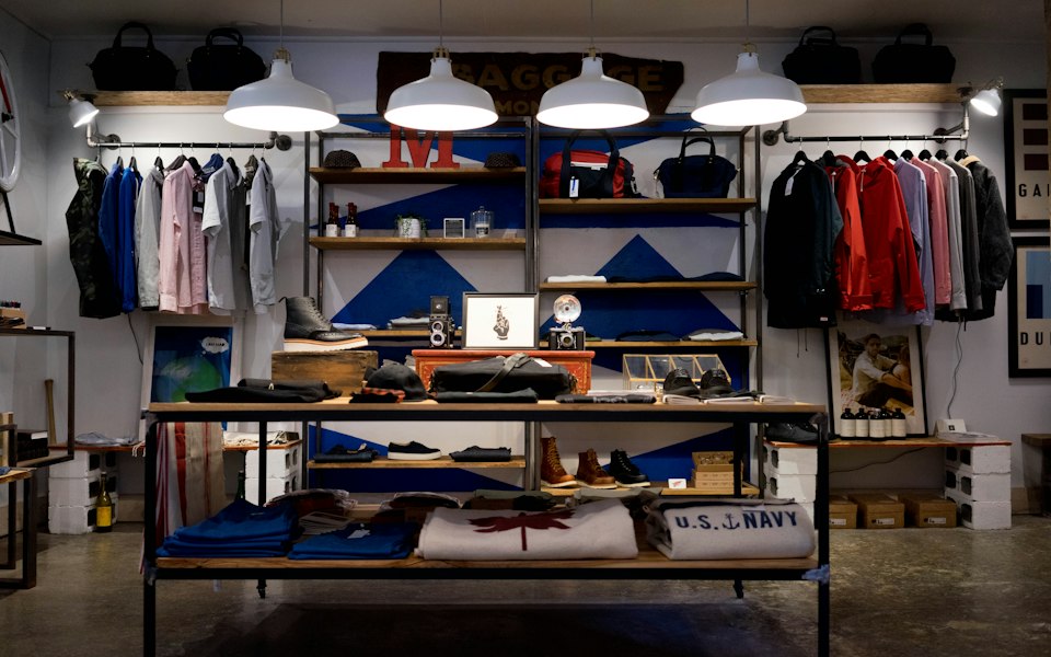 Interior de tienda departamental con ropa exhibida en anaqueles